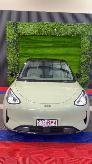 Sage green EV on the red and blue checker floor inside Hustlers Car Studio
