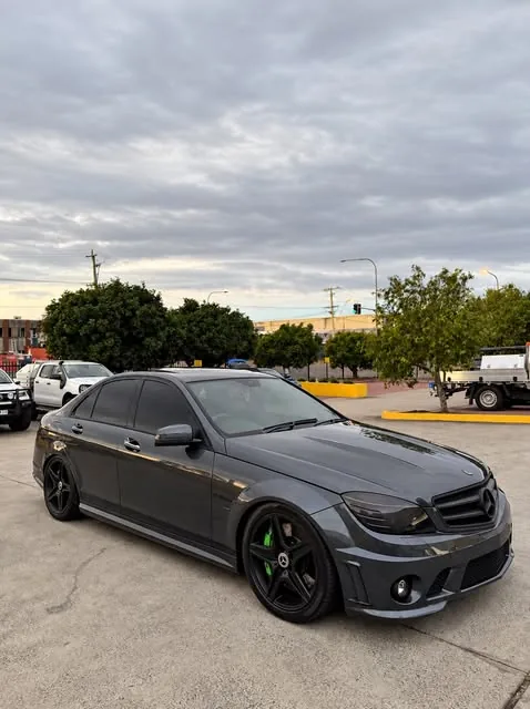 Grey Mercedes-AMG C63 on black wheels with green brake calipers